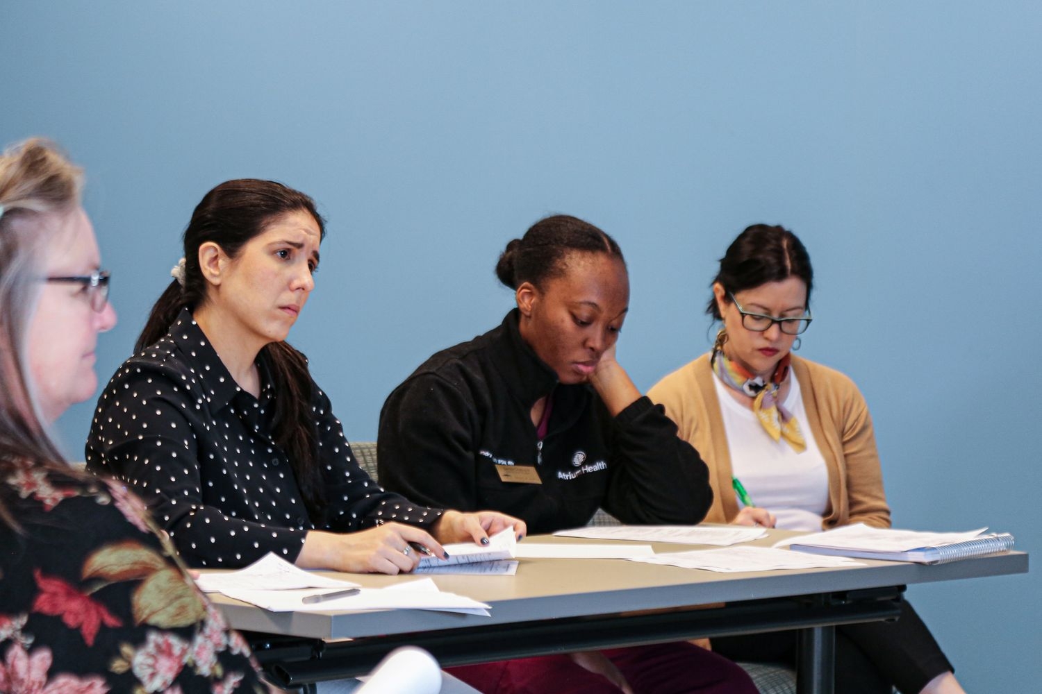 Three Psychiatric Mental Health DNP students observe and take notes during a psychiatric evaluation practice simulation.