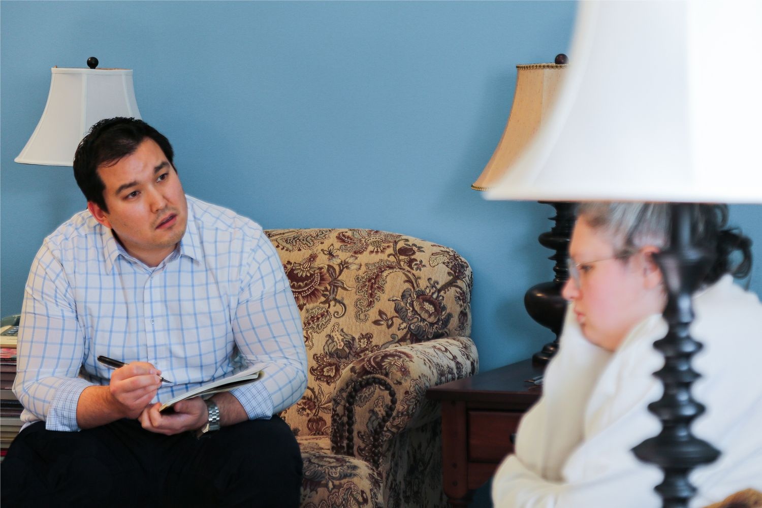 A Psychiatric Mental Health DNP student listens to his client during a psychiatric evaluation practice simulation.
