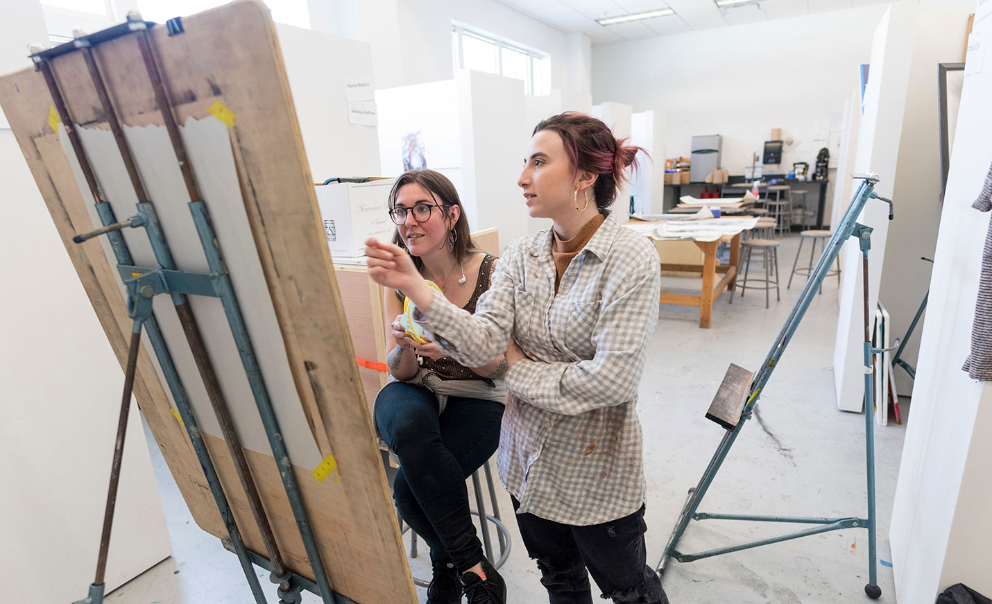 two students discussing art work
