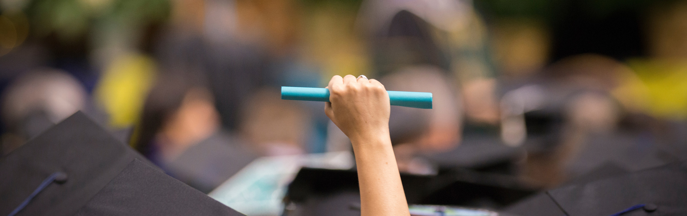 student holding diploma in air