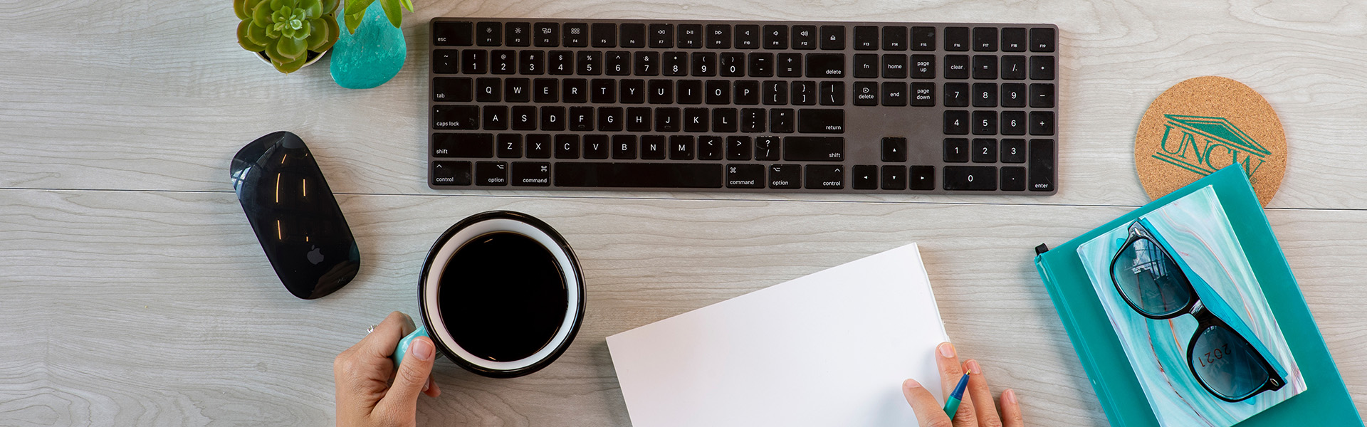 student using laptop with coffee and notebook